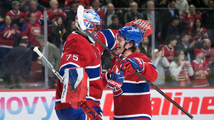 Apr 9, 2026; Montreal, Quebec, CAN; Montreal Canadiens goalie Jakub Dobes (75) and teammate forward Cole Caufield (13) celebrate the win against the Tampa Bay Lightning at the Bell Centre. Mandatory Credit: Eric Bolte-Imagn Images