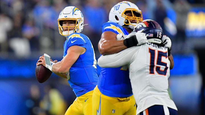 Dec 19, 2024; Inglewood, California, USA; Los Angeles Chargers quarterback Justin Herbert (10) drops back to pass as offensive tackle Rashawn Slater (70) provides coverage against Denver Broncos linebacker Nik Bonitto (15) during the second half at SoFi Stadium.