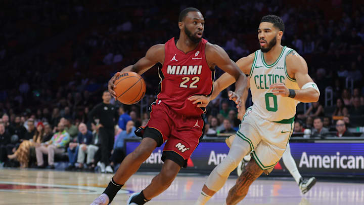 Mar 14, 2025; Miami, Florida, USA; Miami Heat forward Andrew Wiggins (22) drives to the basket against Boston Celtics forward Jayson Tatum (0) during the first quarter at Kaseya Center. Mandatory Credit: Sam Navarro-Imagn Images