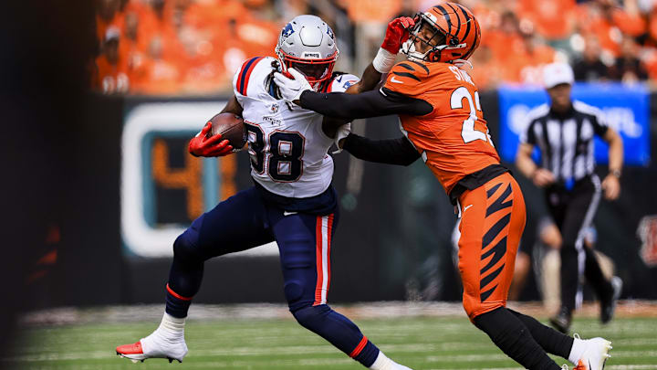Sep 8, 2024; Cincinnati, Ohio, USA; New England Patriots running back Rhamondre Stevenson (38) runs with the ball against Cincinnati Bengals safety Geno Stone (22) in the first half at Paycor Stadium. Mandatory Credit: Katie Stratman-Imagn Images