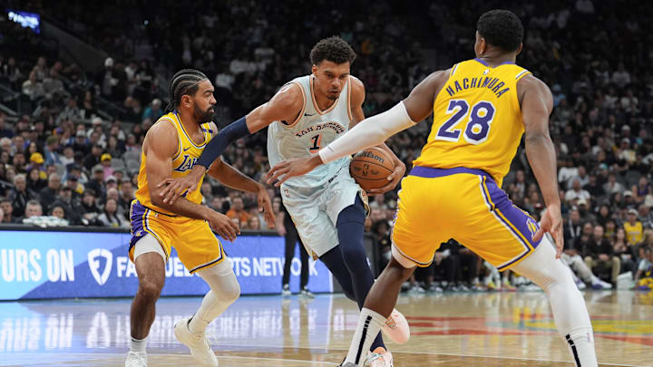 Nov 27, 2024; San Antonio, Texas, USA; San Antonio Spurs center Victor Wembanyama (1) dribbles between Los Angeles Lakers guard Gabe Vincent (7) and forward Rui Hachimura (28) in the first half at Frost Bank Center.