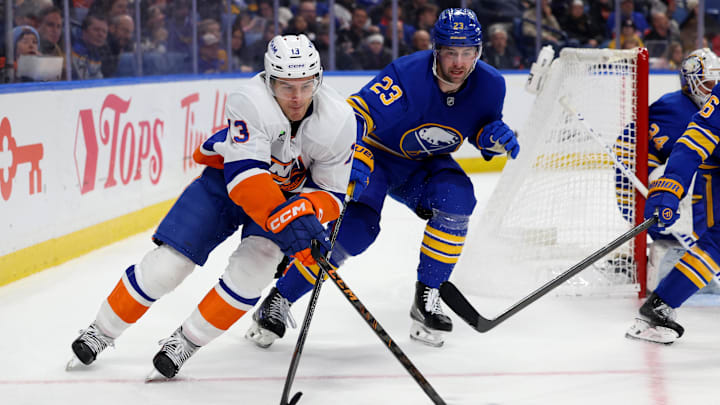 Dec 20, 2025; Buffalo, New York, USA;  New York Islanders center Mathew Barzal (13) looks to control the puck as Buffalo Sabres defenseman Mattias Samuelsson (23) defends during the third period at KeyBank Center. Mandatory Credit: Timothy T. Ludwig-Imagn Images