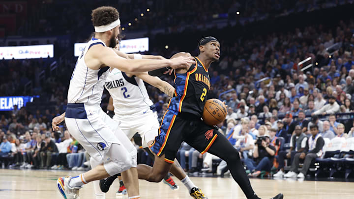 Nov 17, 2024; Oklahoma City, Oklahoma, USA: Oklahoma City Thunder guard Shai Gilgeous-Alexander (2) drives to the basket between Dallas Mavericks guard Klay Thompson (31) and center Dereck Lively II (2) during the second half at Paycom Center. Mandatory Credit: Alonzo Adams-Imagn Images
