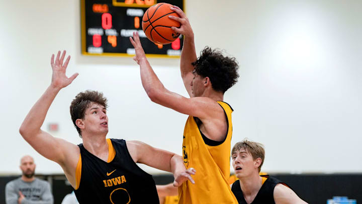 Iowa’s Isaia Howard (23) looks to pass as Trevin Jirak (27) and Cooper Koch (8) defend during practice June 19, 2025 at Carver-Hawkeye Arena in Iowa City, Iowa.