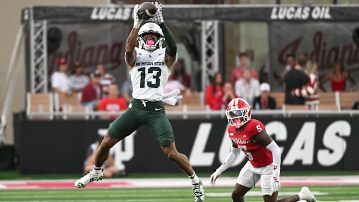Oct 18, 2025; Bloomington, Indiana, USA; Michigan State Spartans wide receiver Chrishon McCray (13) catches a pass against Indiana Hoosiers defensive back D'Angelo Ponds (5) during the first half at Memorial Stadium. Mandatory Credit: Robert Goddin-Imagn Images
