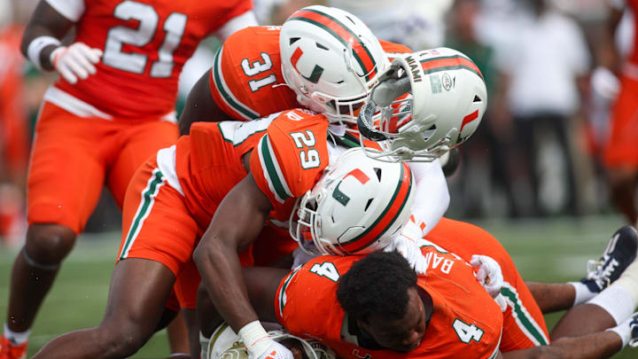 Nov 9, 2024; Atlanta, Georgia, USA; Georgia Tech Yellow Jackets wide receiver Malik Rutherford (8) is tackled by Miami Hurricanes defensive back OJ Frederique Jr. (29) and linebacker Wesley Bissainthe (31) and defensive lineman Rueben Bain Jr. (4) in the second quarter at Bobby Dodd Stadium at Hyundai Field. Mandatory Credit: Brett Davis-Imagn Images
Nov 9, 2024; Atlanta, Georgia, USA; Georgia Tech Yellow Jackets wide receiver Malik Rutherford (8) is tackled by Miami Hurricanes defensive back OJ Frederique Jr. (29) and linebacker Wesley Bissainthe (31) and defensive lineman Rueben Bain Jr. (4) in the second quarter at Bobby Dodd Stadium at Hyundai Field. Mandatory Credit: Brett Davis-Imagn Images