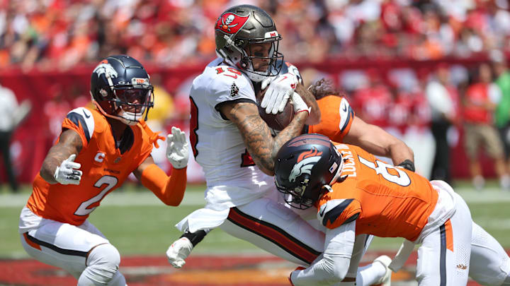 Sep 22, 2024; Tampa, Florida, USA; Denver Broncos safety P.J. Locke (6), cornerback Pat Surtain II (2) and linebacker Alex Singleton (49) tackle Tampa Bay Buccaneers wide receiver Mike Evans (13) after a reception during the first half at Raymond James Stadium. Mandatory Credit: Kim Klement Neitzel-Imagn Images
