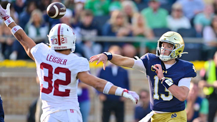 Oct 12, 2024; South Bend, Indiana, USA; Notre Dame Fighting Irish quarterback Riley Leonard (13) throws a pass for a touchdown as Stanford Cardinal safety Mitch Leigber (32) defends in the second quarter at Notre Dame Stadium. Mandatory Credit: Matt Cashore-Imagn Images Oct 12, 2024; South Bend, Indiana, USA; Notre Dame Fighting Irish quarterback Riley Leonard (13) throws a pass for a touchdown as Stanford Cardinal safety Mitch Leigber (32) defends in the second quarter at Notre Dame Stadium. Mandatory Credit: Matt Cashore-Imagn Images