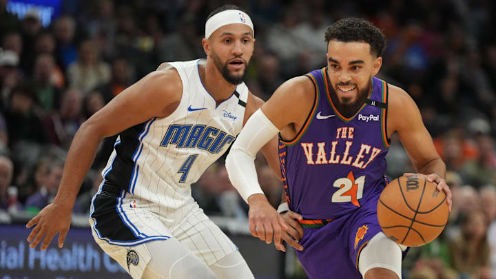 Nov 18, 2024; Phoenix, Arizona, USA; Phoenix Suns guard Tyus Jones (21) drives on Orlando Magic guard Jalen Suggs (4) during the first half of an NBA game at Footprint Center. Mandatory Credit: Rick Scuteri-Imagn Images