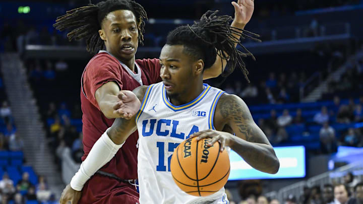 Nov 4, 2024; Los Angeles, California, USA; UCLA Bruins guard Sebastian Mack (12) drives to the basket defended by Rider Broncs forward Ife West-Ingram (7) during the first half at Pauley Pavilion presented by Wescom. Mandatory Credit: Robert Hanashiro-Imagn Images