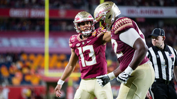 Florida State Seminoles quarterback Jordan Travis (13) pats his teammate  s helmet after the team scored a touchdown. The Florida State Seminoles defeated the Oklahoma Sooners 35-32 in the Cheez-It Bowl at Camping World Stadium on Thursday, Dec. 29, 2022.

Fsu V Oklahoma Second Half122a