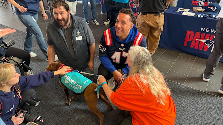 New England Patriots long snapper Julian Ashby spending time with a dog at the Patriots Foundation's "Pawtriots" draft day event.