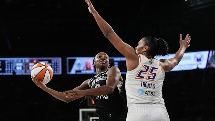 Oct 5, 2025; Las Vegas, Nevada, USA; Las Vegas Aces guard Jackie Young (0) drives the ball against Phoenix Mercury forward Alyssa Thomas (25) during the third quarter of game two of the 2025 WNBA Finals at Michelob Ultra Arena. Mandatory Credit: Lucas Peltier-Imagn Images