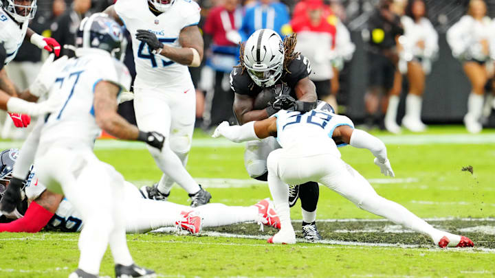 Oct 12, 2025; Paradise, Nevada, USA; Las Vegas Raiders running back Ashton Jeanty (2) runs the ball against Tennessee Titans cornerback L'Jarius Sneed (38) during the first half at Allegiant Stadium. Mandatory Credit: Stephen R. Sylvanie-Imagn Images