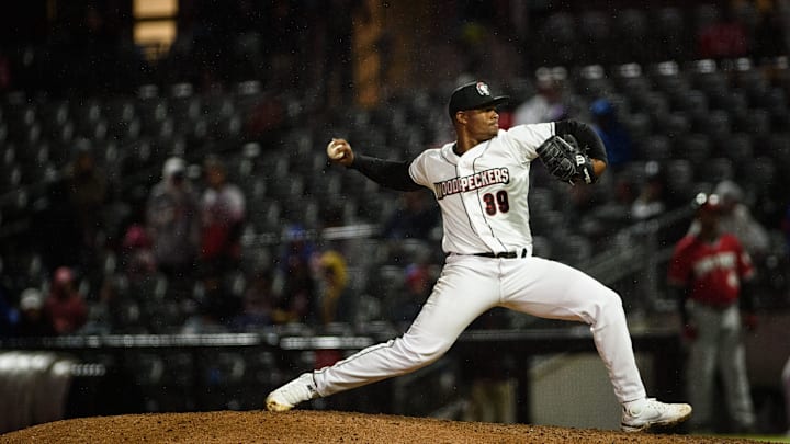 Alimber Santa throwing a pitch in all white uniform. 