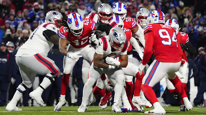 New England Patriots running back Antonio Gibson (4) runs with the ball against Buffalo Bills linebacker Dorian Williams (42) and defensive end Dawuane Smoot (94) during the first half at Highmark Stadium.