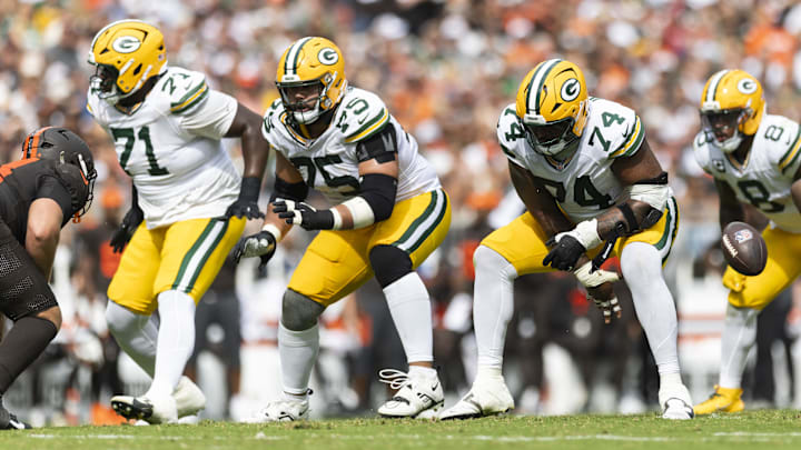 Sep 21, 2025; Cleveland, Ohio, USA; Green Bay Packers guard Elgton Jenkins (74) snaps the ball as guard Sean Rhyan (75) and offensive tackle Anthony Belton (71) move for blocks against the Cleveland Browns during the third quarter at Huntington Bank Field. Mandatory Credit: Scott Galvin-Imagn Images