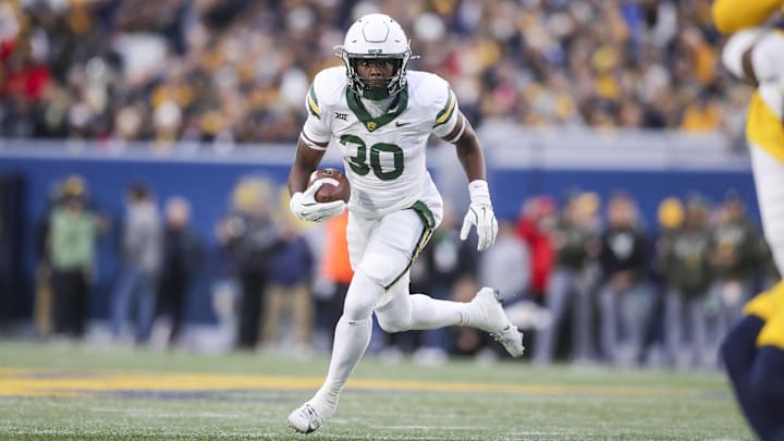 Nov 16, 2024; Morgantown, West Virginia, USA; Baylor Bears running back Bryson Washington (30) runs the ball during the first quarter against the West Virginia Mountaineers at Mountaineer Field at Milan Puskar Stadium. Mandatory Credit: Ben Queen-Imagn Images
