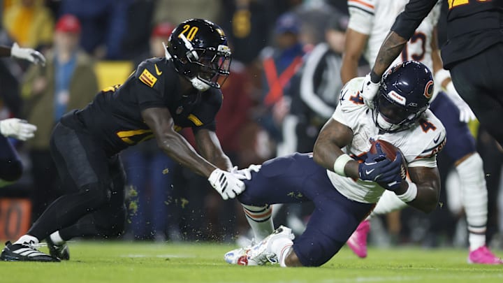 Bears running back D'Andre Swift  slips while defended by Washington Commanders safety Quan Martin in the first half Monday night.