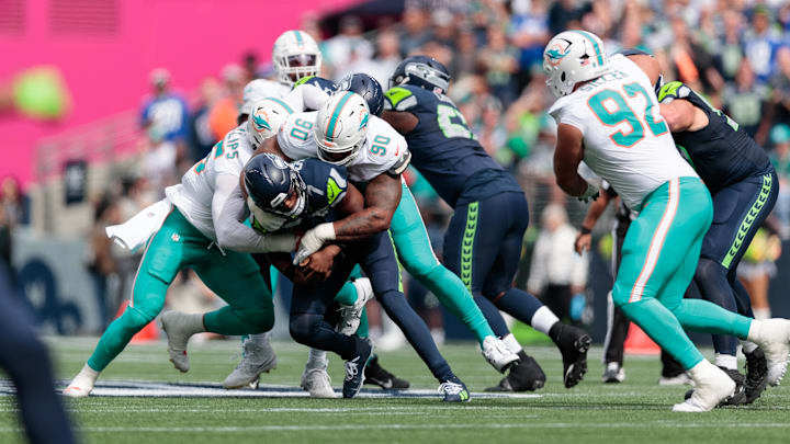 Seattle Seahawks quarterback Geno Smith (7) is sacked by Miami Dolphins defensive tackle Da'Shawn Hand (90) during the first quarter at Lumen Field.