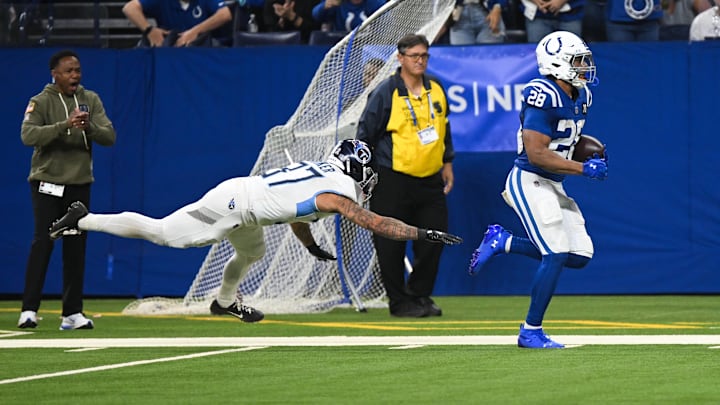 Oct 26, 2025; Indianapolis, Indiana, USA;  Indianapolis Colts running back Jonathan Taylor (28) rushes for a touchdown as Tennessee Titans safety Amani Hooker (37) defends during the third quarter at Lucas Oil Stadium. Mandatory Credit: Robert Goddin-Imagn Images