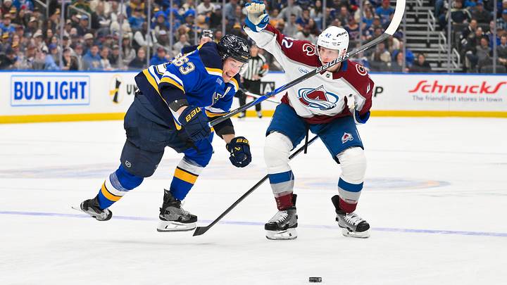 Apr 7, 2026; St. Louis, Missouri, USA; St. Louis Blues left wing Jake Neighbours (63) collides with Colorado Avalanche defenseman Josh Manson (42) as they battle for the puck during the second period at Enterprise Center. Mandatory Credit: Jeff Curry-Imagn Images