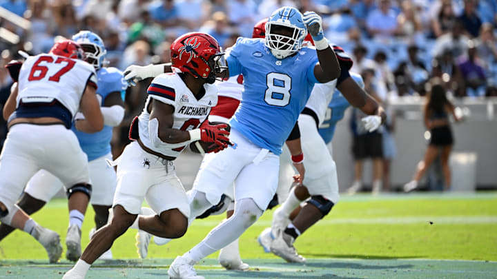 Sep 13, 2025; Chapel Hill, North Carolina, USA; Richmond Spiders running back Andrew King (8) runs as North Carolina Tar Heels defensive lineman Smith Vilbert (8) defends in the second quarter at Kenan Stadium.