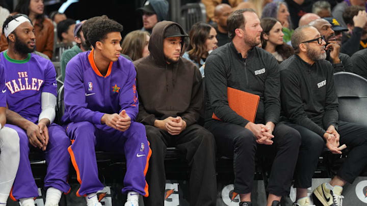 Dec 21, 2024; Phoenix, Arizona, USA; Phoenix Suns guard Devin Booker (center) looks on against the Detroit Pistons during the second half at Footprint Center. Mandatory Credit: Joe Camporeale-Imagn Images
