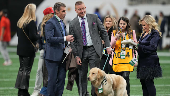 Jan 20, 2025; Atlanta, GA, USA; ESPN broadcast team of Chris Fowler, Kirk Herbstreit and Holly Rowe with golden retriever Peter before the CFP National Championship college football game between the Notre Dame Fighting Irish and the Ohio State Buckeyes at Mercedes-Benz Stadium. Mandatory Credit: Kirby Lee-Imagn Images