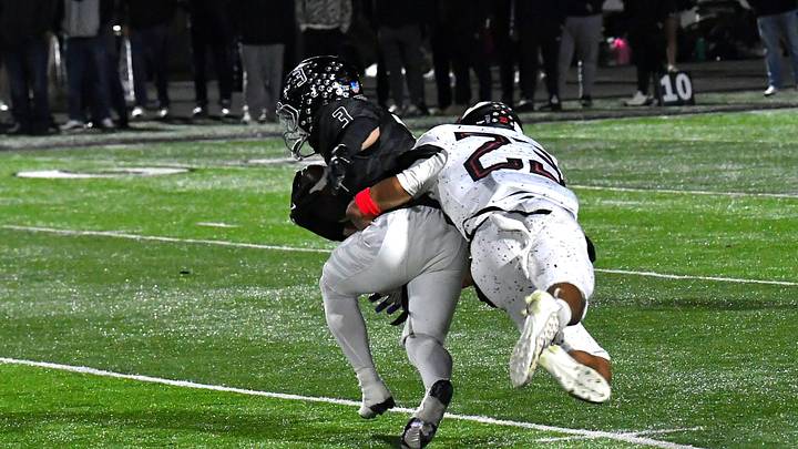 Kenyon Norman (3) of Lakota East is dropped for a loss by Roman Combs (23) of Lakota West at the Greater Miami Conference football game, Oct. 24, 2025.
