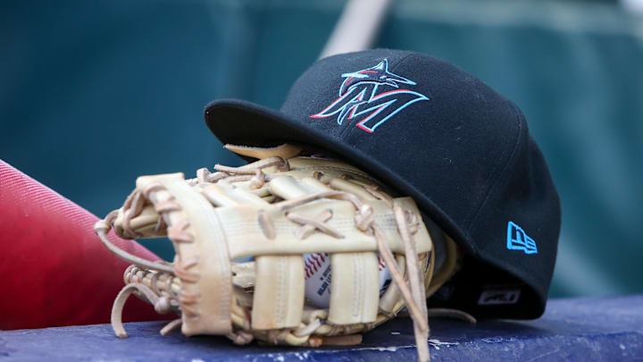 Apr 24, 2024; Atlanta, Georgia, USA; A detailed view of a Miami Marlins hat and glove in the dugout before a game against the Atlanta Braves at Truist Park.