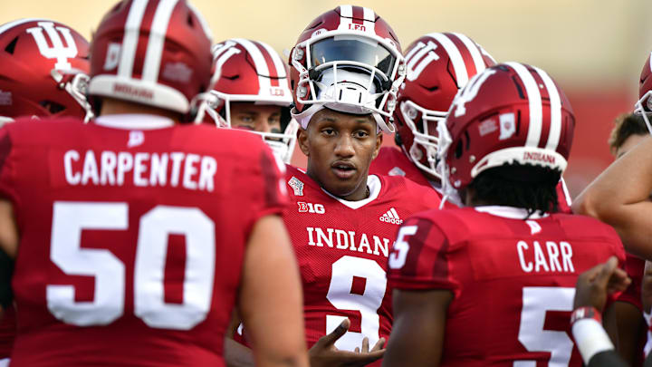 As the; Indiana quarterback, Michael Penix Jr. (9) meets with teammates before a game against the Idaho Vandals.