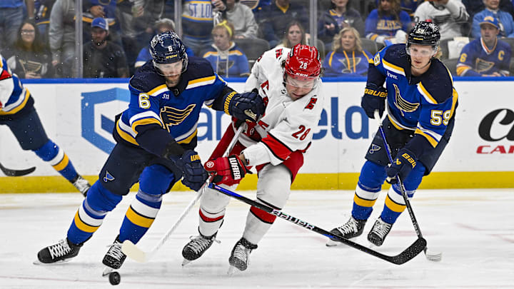 Apr 12, 2024; St. Louis, Missouri, USA;  St. Louis Blues defenseman Marco Scandella (6) and Carolina Hurricanes left wing Brendan Lemieux (28) battle for the puck during the first period at Enterprise Center. Mandatory Credit: Jeff Curry-Imagn Images