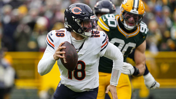 Jan 5, 2025; Green Bay, Wisconsin, USA;  Chicago Bears quarterback Caleb Williams (18) scrambles away from pressure applied by Green Bay Packers defensive lineman Lukas Van Ness (90) during the first quarter at Lambeau Field. Mandatory Credit: Jeff Hanisch-Imagn Images