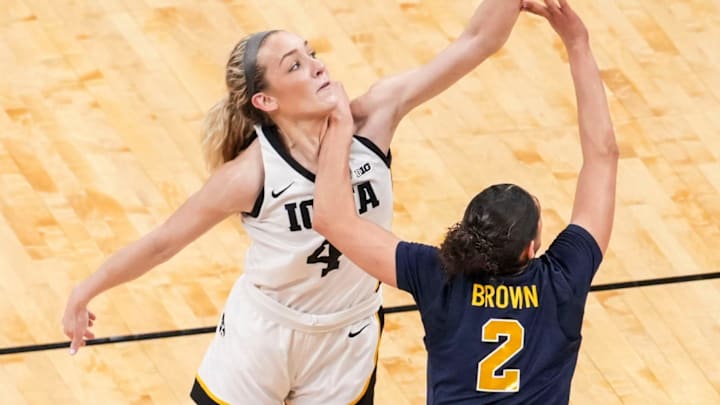 Iowa Hawkeyes guard Kylie Feuerbach (4) and Michigan Wolverines guard Macy Brown (2) go for the ball Saturday, March 7, 2026, during a Big Ten women's basketball tournament semifinals game at Gainbridge Fieldhouse in Indianapolis. Iowa Hawkeyes guard Kylie Feuerbach (4) and Michigan Wolverines guard Macy Brown (2) go for the ball Saturday, March 7, 2026, during a Big Ten women's basketball tournament semifinals game at Gainbridge Fieldhouse in Indianapolis.
