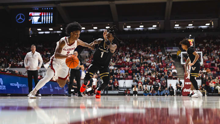 Jan 21, 2025; Tuscaloosa, Alabama, USA; Alabama Crimson Tide guard Aden Holloway (2) drives the ball against Vanderbilt Commodores guard Jason Edwards (1) during the first half at Coleman Coliseum. Mandatory Credit: Will McLelland-Imagn Images