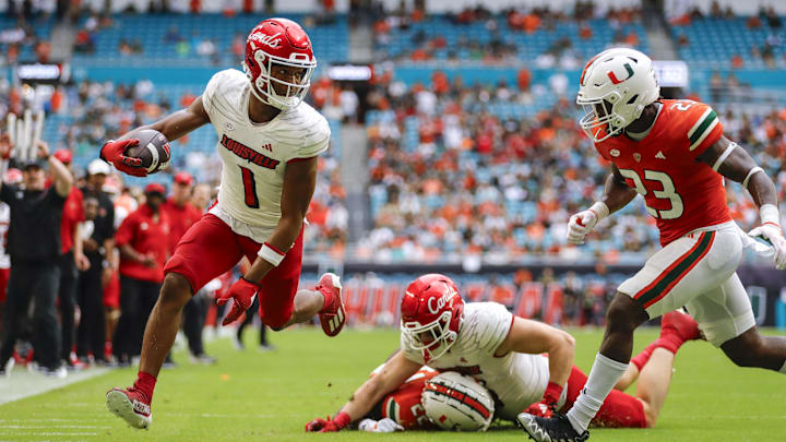 Nov 18, 2023; Miami Gardens, Florida, USA; Louisville Cardinals wide receiver Jamari Thrash (1) runs with the football for a touchdown against Miami Hurricanes linebacker K.J. Cloyd (23) during the fourth quarter at Hard Rock Stadium. 