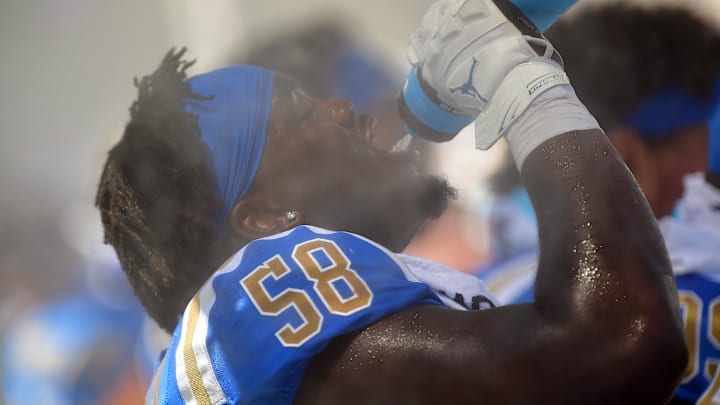 Sep 3, 2022; Pasadena, California, USA; UCLA Bruins defensive lineman Gary Smith III (58) drinks water and cools off at a misting station during the second half at Rose Bowl. Mandatory Credit: Gary A. Vasquez-Imagn Images