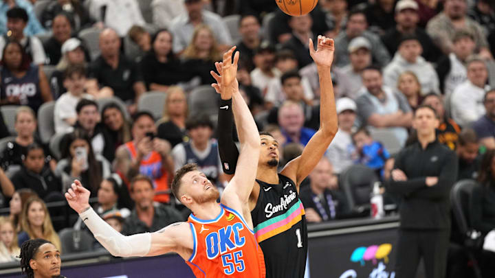 Dec 23, 2025; San Antonio, Texas, USA; San Antonio Spurs forward Victor Wembanyama (1) and Oklahoma City Thunder center Isaiah Hartenstein (55) in a jump ball during the first half at Frost Bank Center. Mandatory Credit: Scott Wachter-Imagn Images