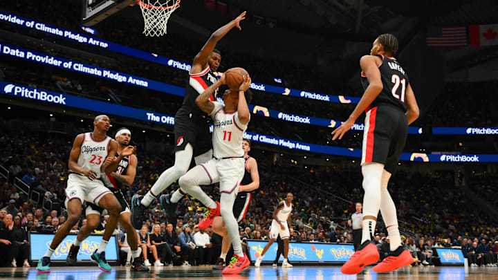 Oct 11, 2024; Seattle, Washington, USA; Los Angeles Clippers guard Jordan Miller (11) shoots the ball while fouled by Portland Trail Blazers forward Jabari Walker (34) during the first half at Climate Pledge Arena. Mandatory Credit: Steven Bisig-Imagn Images