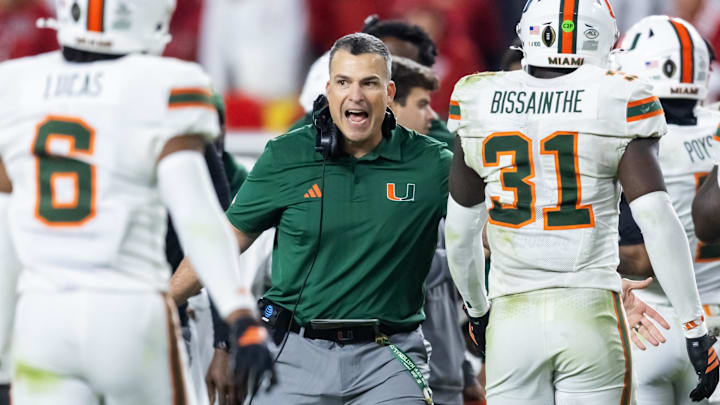 Jan 19, 2026; Miami Gardens, FL, USA; Miami Hurricanes head coach Mario Cristobal with linebacker Wesley Bissainthe (31) against the Indiana Hoosiers during the College Football Playoff National Championship game at Hard Rock Stadium. Mandatory Credit: Mark J. Rebilas-Imagn Images