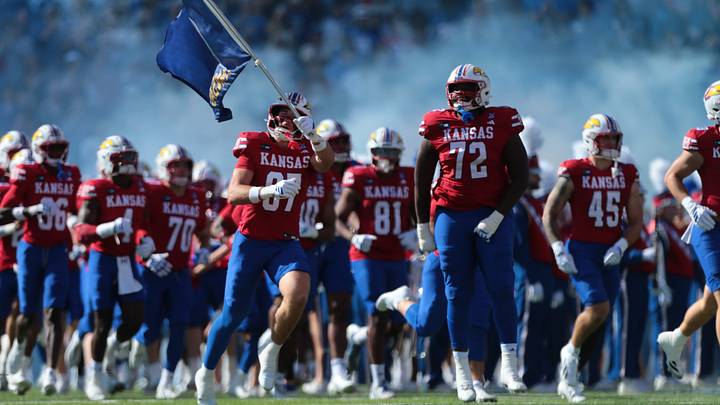 Kansas Jayhawks players run on to the field to take on Middle Tennessee Blue Raiders before the game inside David Booth Kansas Memorial Stadium on October 3, 2026. Kansas Jayhawks players run on to the field to take on Middle Tennessee Blue Raiders before the game inside David Booth Kansas Memorial Stadium on October 3, 2026.