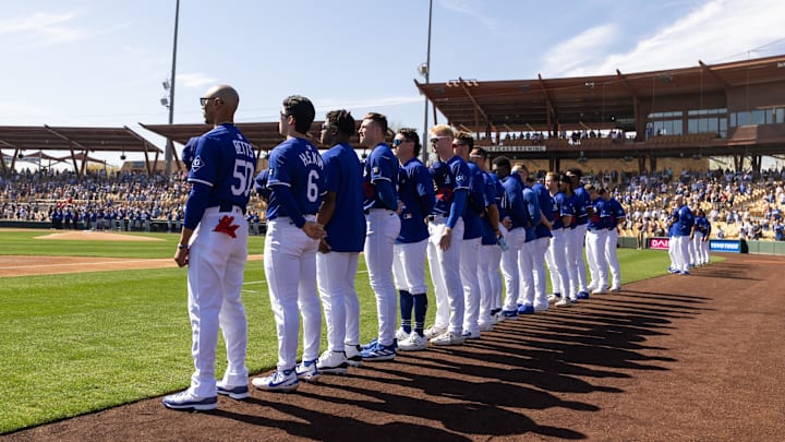 Phoenix, Arizona, USA; Los Angeles Dodgers players stand on the field during the national anthem prior to the spring training game against the Chicago Cubs at Camelback Ranch-Glendale. Phoenix, Arizona, USA; Los Angeles Dodgers players stand on the field during the national anthem prior to the spring training game against the Chicago Cubs at Camelback Ranch-Glendale.