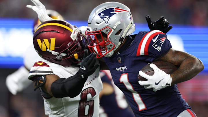Washington Commanders cornerback Noah Igbinoghene (6) tackles New England Patriots receiver Ja'Lynn Polk (1) during the first half at Gillette Stadium.