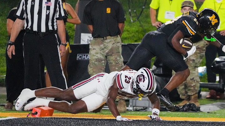 Sep 20, 2025; Columbia, Missouri, USA; Missouri Tigers running back Jamal Roberts (20) scores a touchdown as South Carolina Gamecocks defensive back David Bucey (13) attempts the tackle during the second half of the game at Faurot Field at Memorial Stadium. Mandatory Credit: Denny Medley-Imagn Images