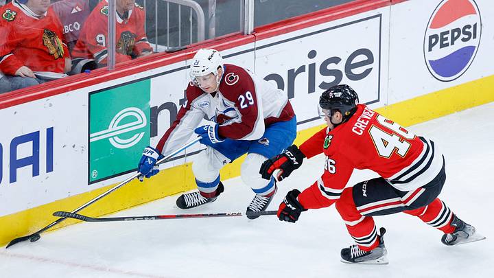 Nov 23, 2025; Chicago, Illinois, USA; Chicago Blackhawks defenseman Louis Crevier (46) defends against Colorado Avalanche center Nathan MacKinnon (29) during the second period at United Center. Mandatory Credit: Kamil Krzaczynski-Imagn Images