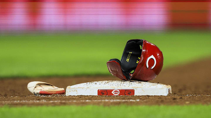 Jul 29, 2024; Cincinnati, Ohio, USA; The helmet and sliding glove of Cincinnati Reds catcher Tyler Stephenson (not pictured) sits on first base during a stop in play in the eighth inning in the game against the Chicago Cubs at Great American Ball Park. Mandatory Credit: Katie Stratman-Imagn Images Jul 29, 2024; Cincinnati, Ohio, USA; The helmet and sliding glove of Cincinnati Reds catcher Tyler Stephenson (not pictured) sits on first base during a stop in play in the eighth inning in the game against the Chicago Cubs at Great American Ball Park. Mandatory Credit: Katie Stratman-Imagn Images