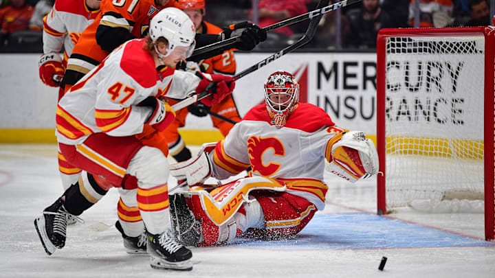 Jan 7, 2025; Anaheim, California, USA; Calgary Flames goaltender Dustin Wolf (32) defends the goal as center Connor Zary (47) moves in for the rebound against Anaheim Ducks left wing Cutter Gauthier (61) during the second period at Honda Center. Mandatory Credit: Gary A. Vasquez-Imagn Images