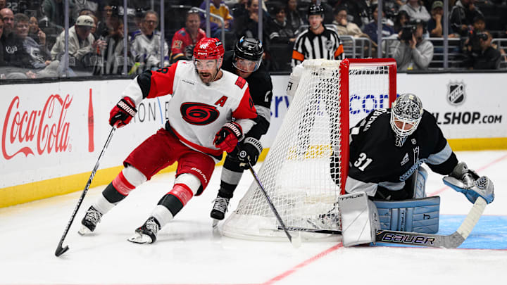 Oct 18, 2025; Los Angeles, California, USA; Carolina Hurricanes left wing Jordan Martinook (48) and Los Angeles Kings defenseman Brian Dumoulin (2) vie for the puck during the third period at Crypto.com Arena. Mandatory Credit: William Liang-Imagn Images
