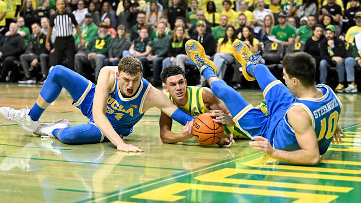 Dec 8, 2024; Eugene, Oregon, USA; Oregon Ducks guard Jackson Shelstad (3) battles for the ball against  UCLA Bruins forward Tyler Bilodeau (34) and guard Lazar Stefanovic (10) in the first half at Matthew Knight Arena.
